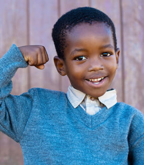 smiling child with fist in the air