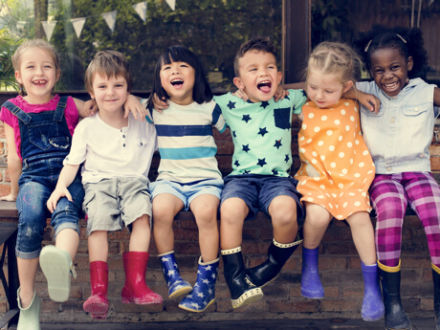 group of children sat laughing at the camera